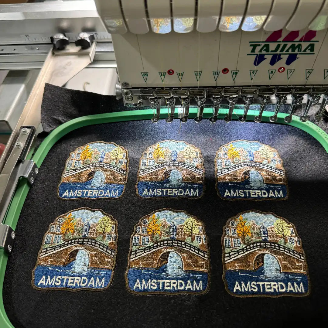 Embroidery machine with 'Amsterdam' designs on a black fabric