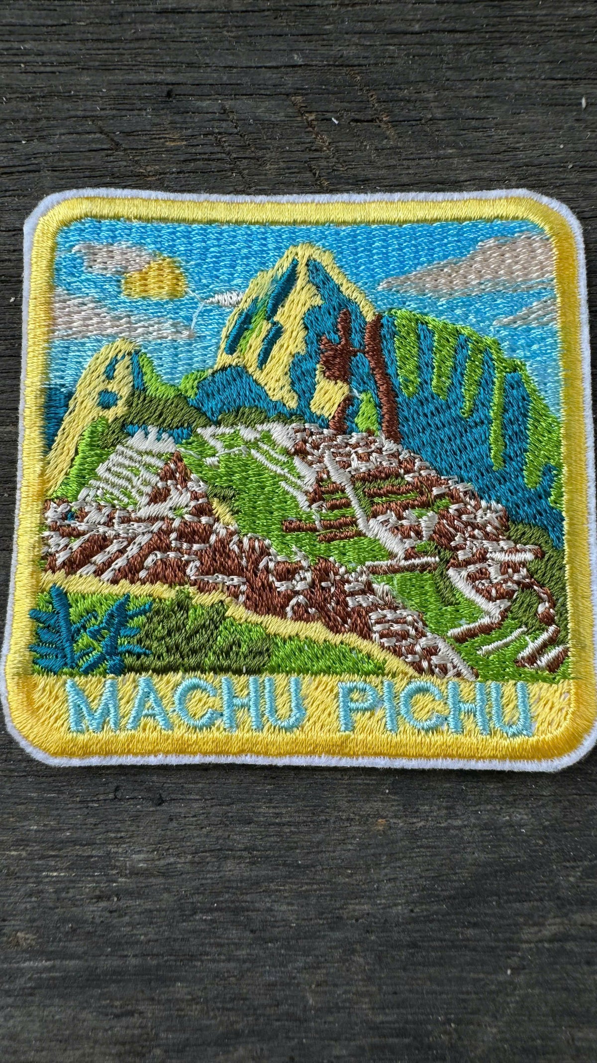 Embroidered patch of Machu Picchu on a dark surface