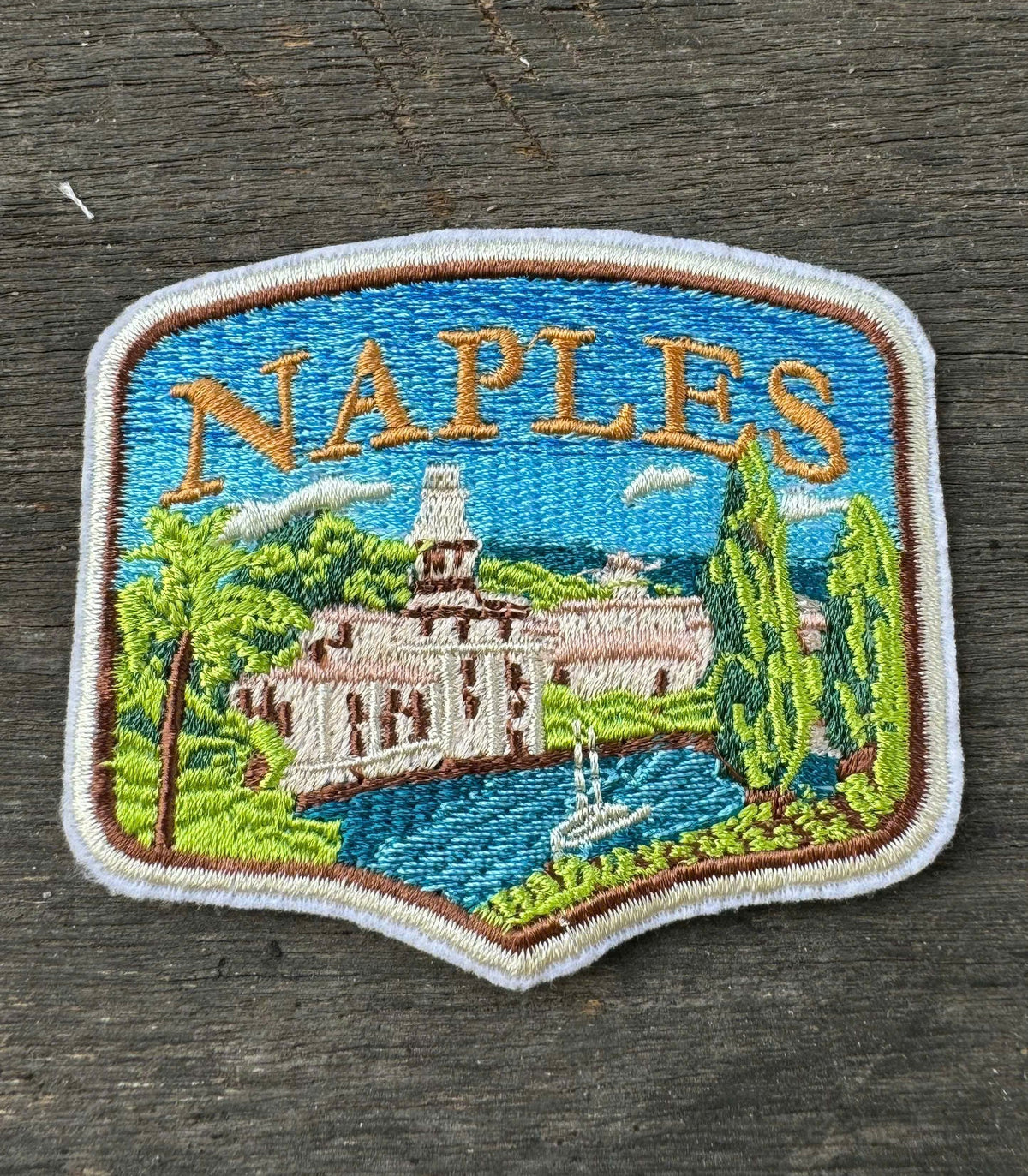 Embroidered patch of Naples on a wooden surface