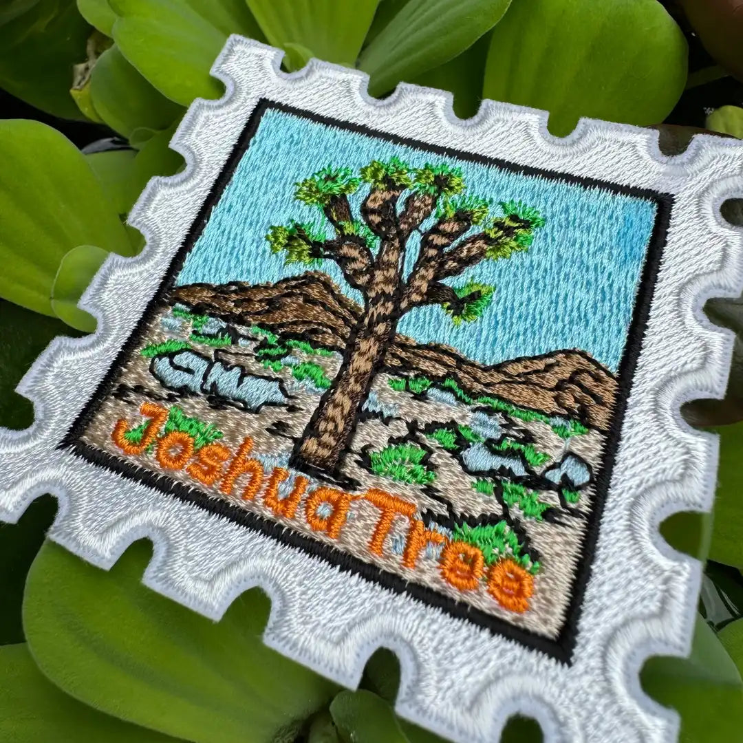 Embroidered patch of a Joshua Tree with desert landscape on a green leaf background