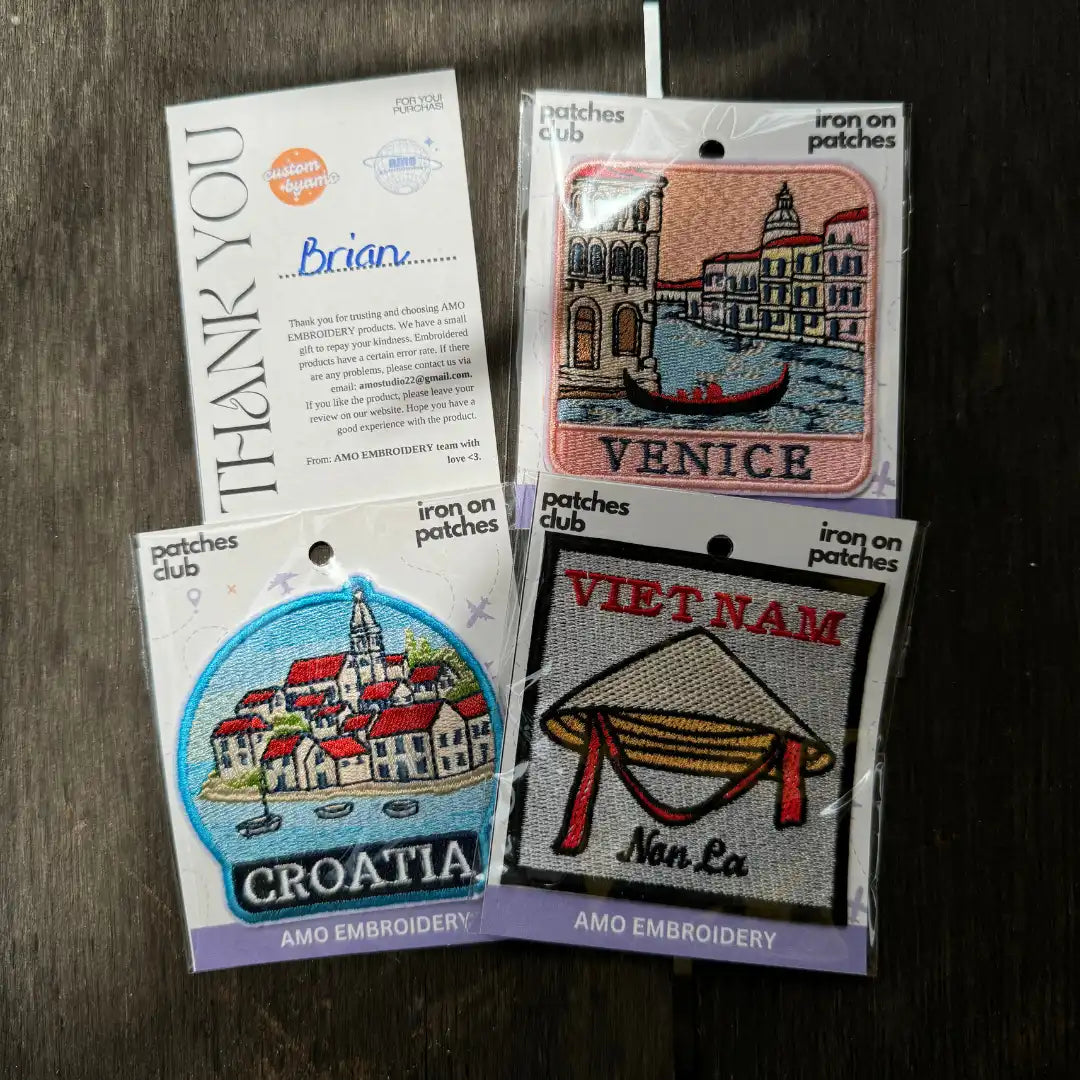 Iron-on patches with designs of Venice, Croatia, and Vietnam on packaging