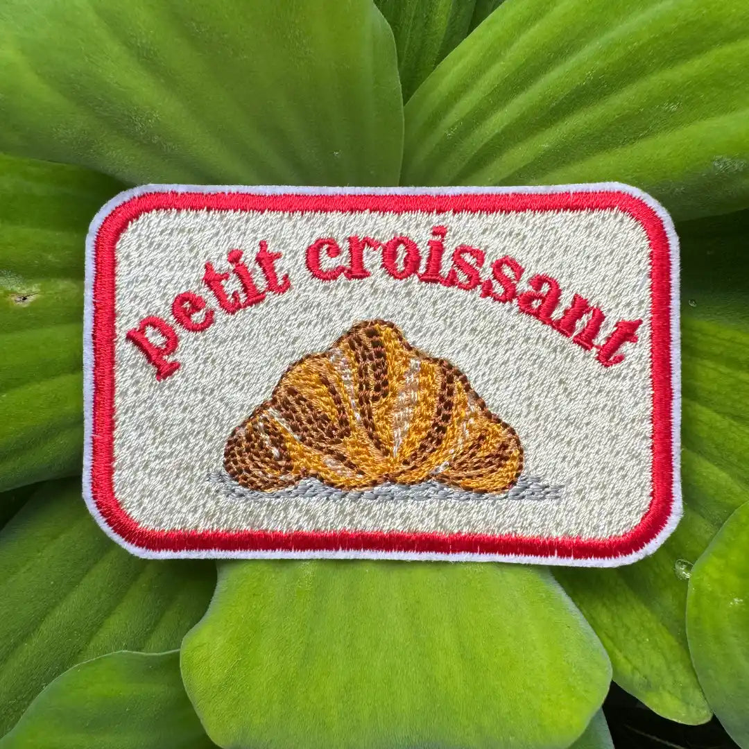 Golden embroidered croissant with text 'Petit croissant
