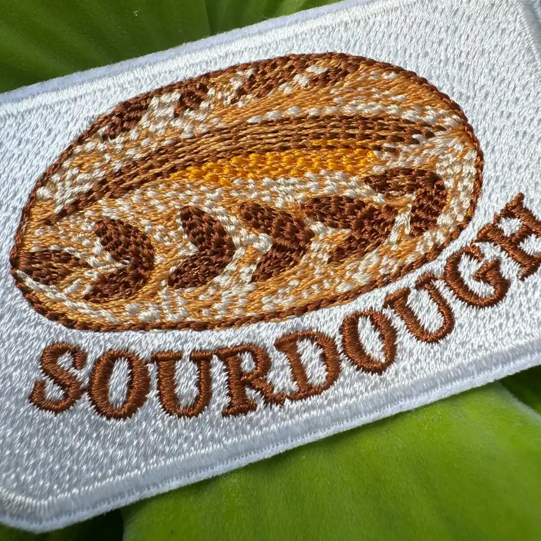 Embroidered patch of a sourdough bread loaf on a white background