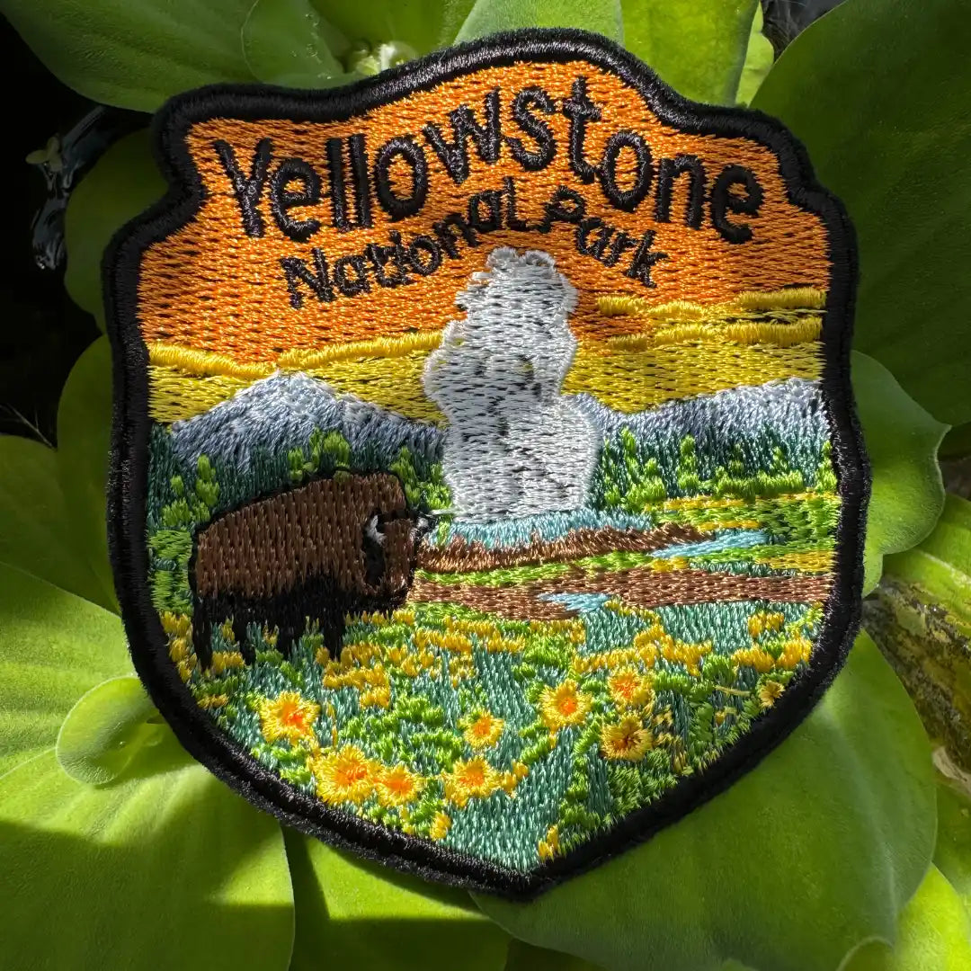 Colorful patch showing Old Faithful geyser and sunset