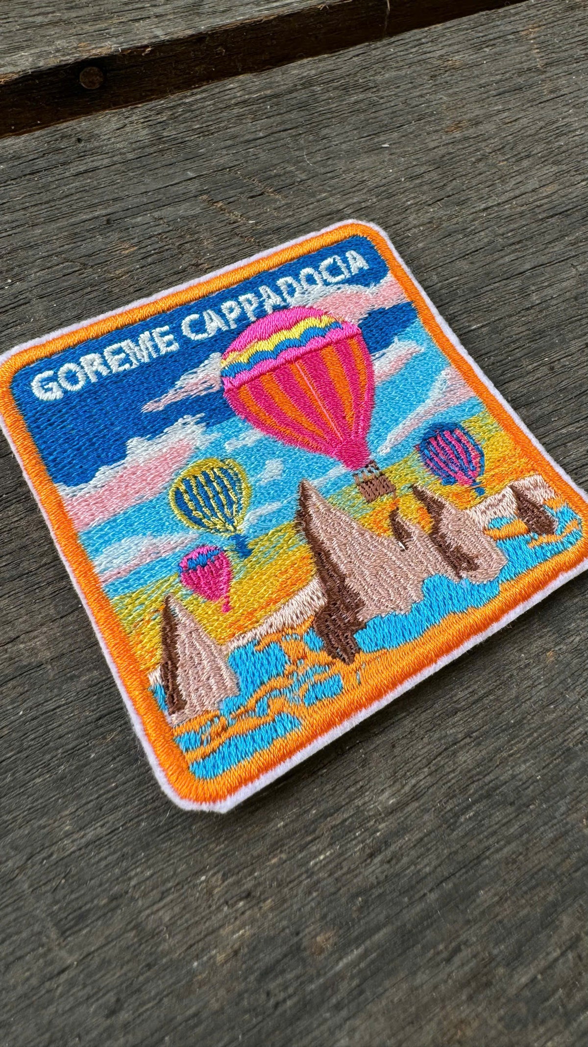 Embroidered patch of Goreme Cappadocia with hot air balloons on a wooden surface