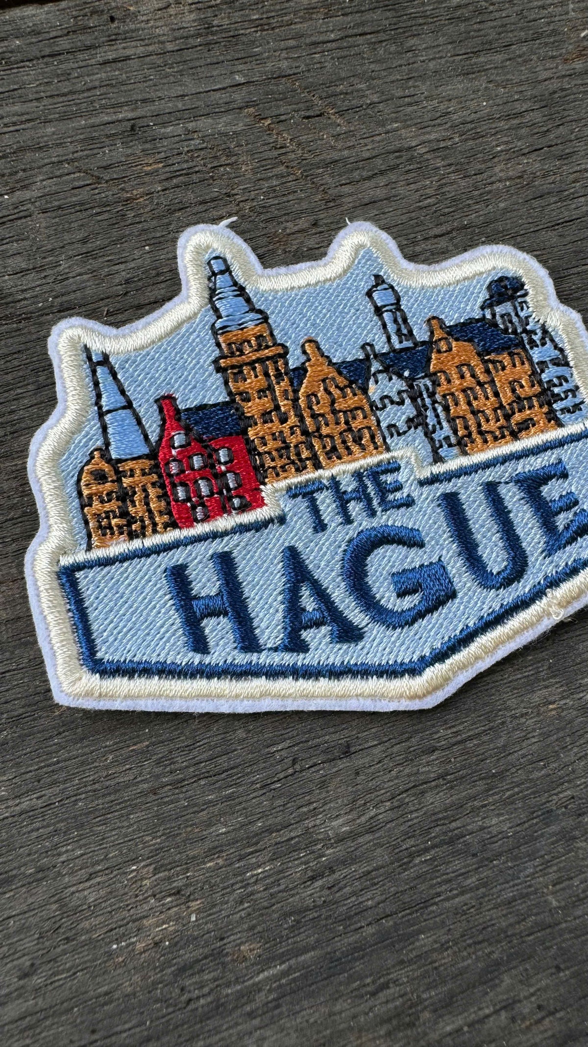 Embroidered patch of Switzerland with a mountain and flag design on a wooden surface