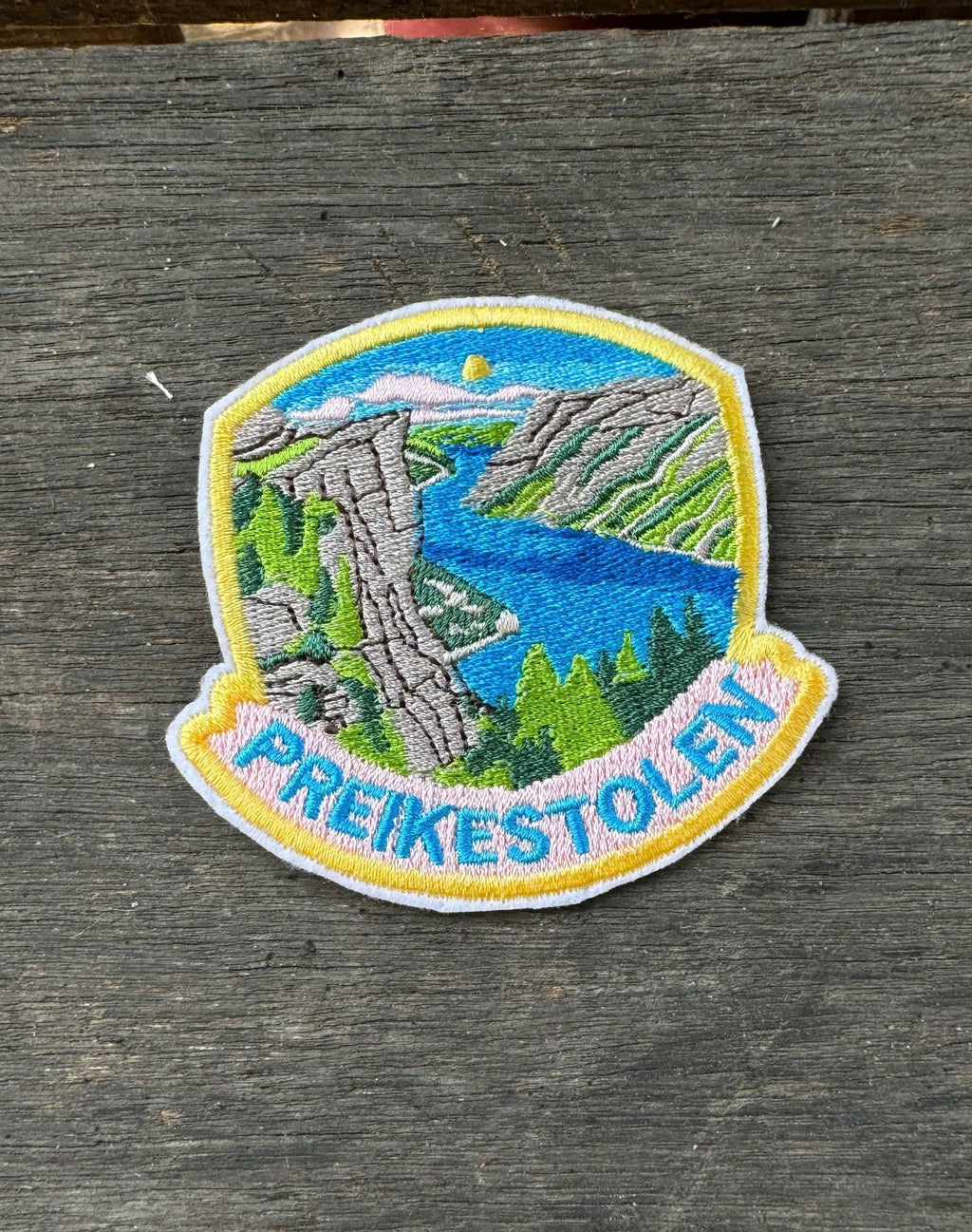 Embroidered patch of Preikestolen on a wooden surface