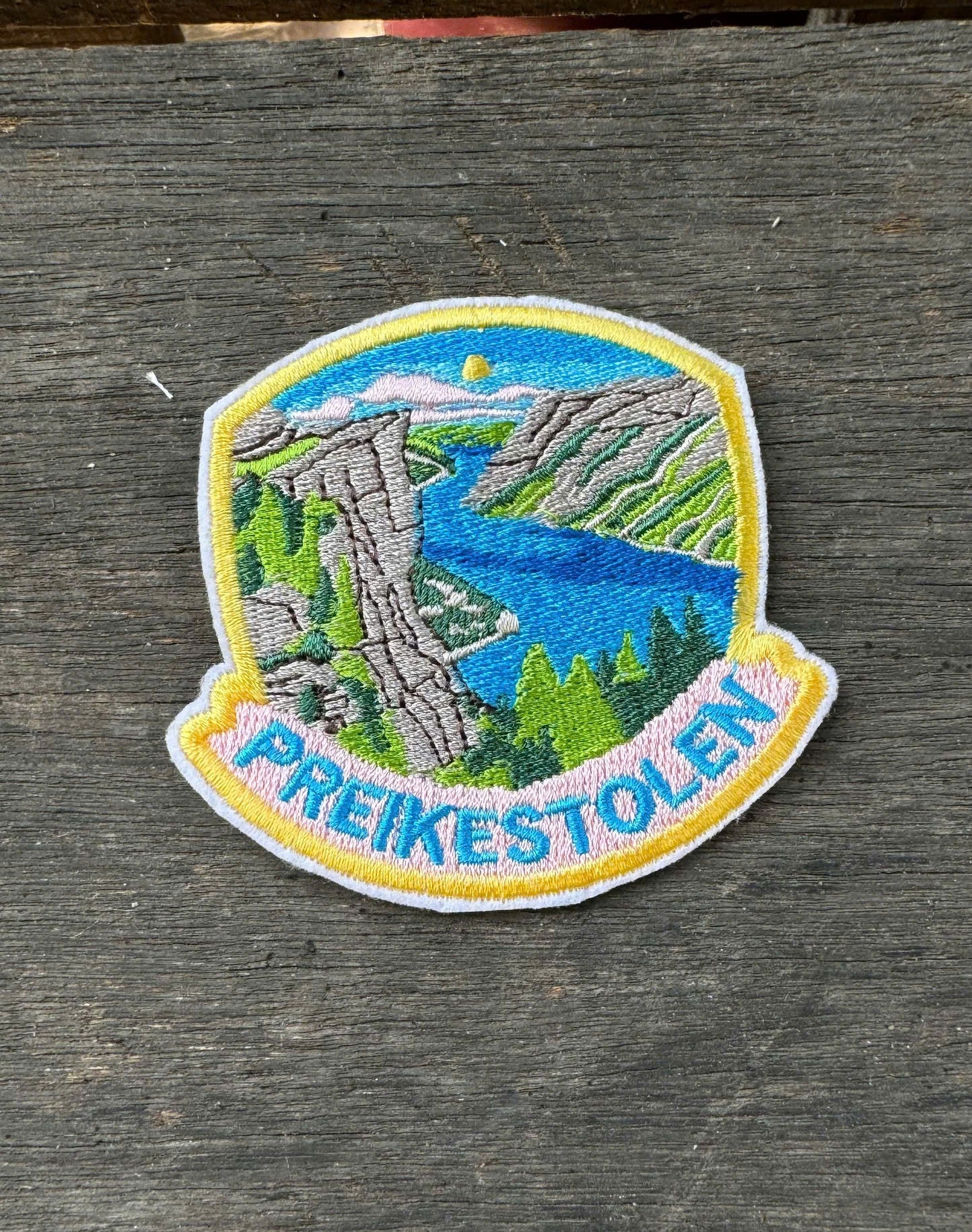 Embroidered patch of Preikestolen on a wooden surface