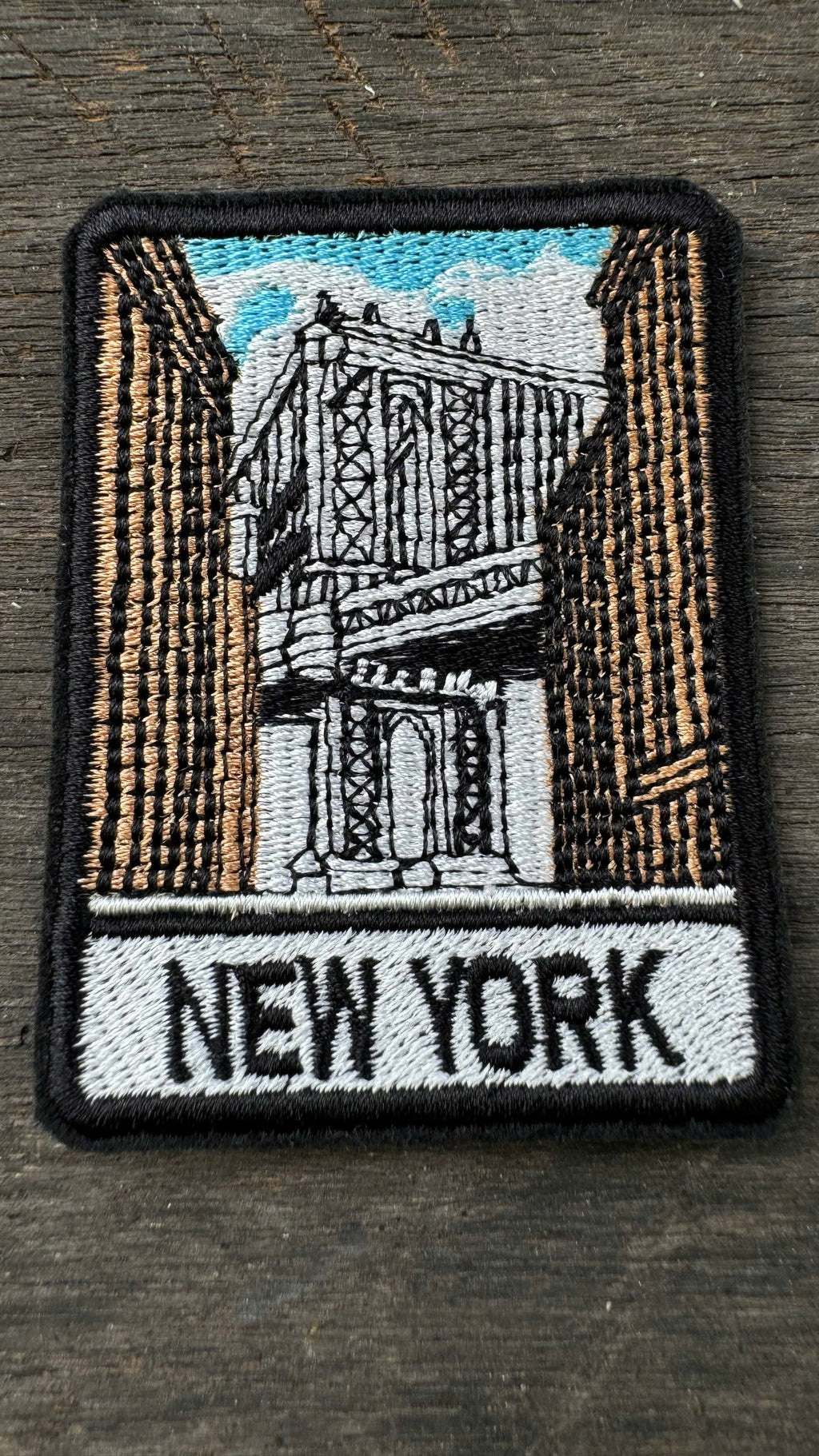 Embroidered patch with a New York Cityscape design on a wooden surface