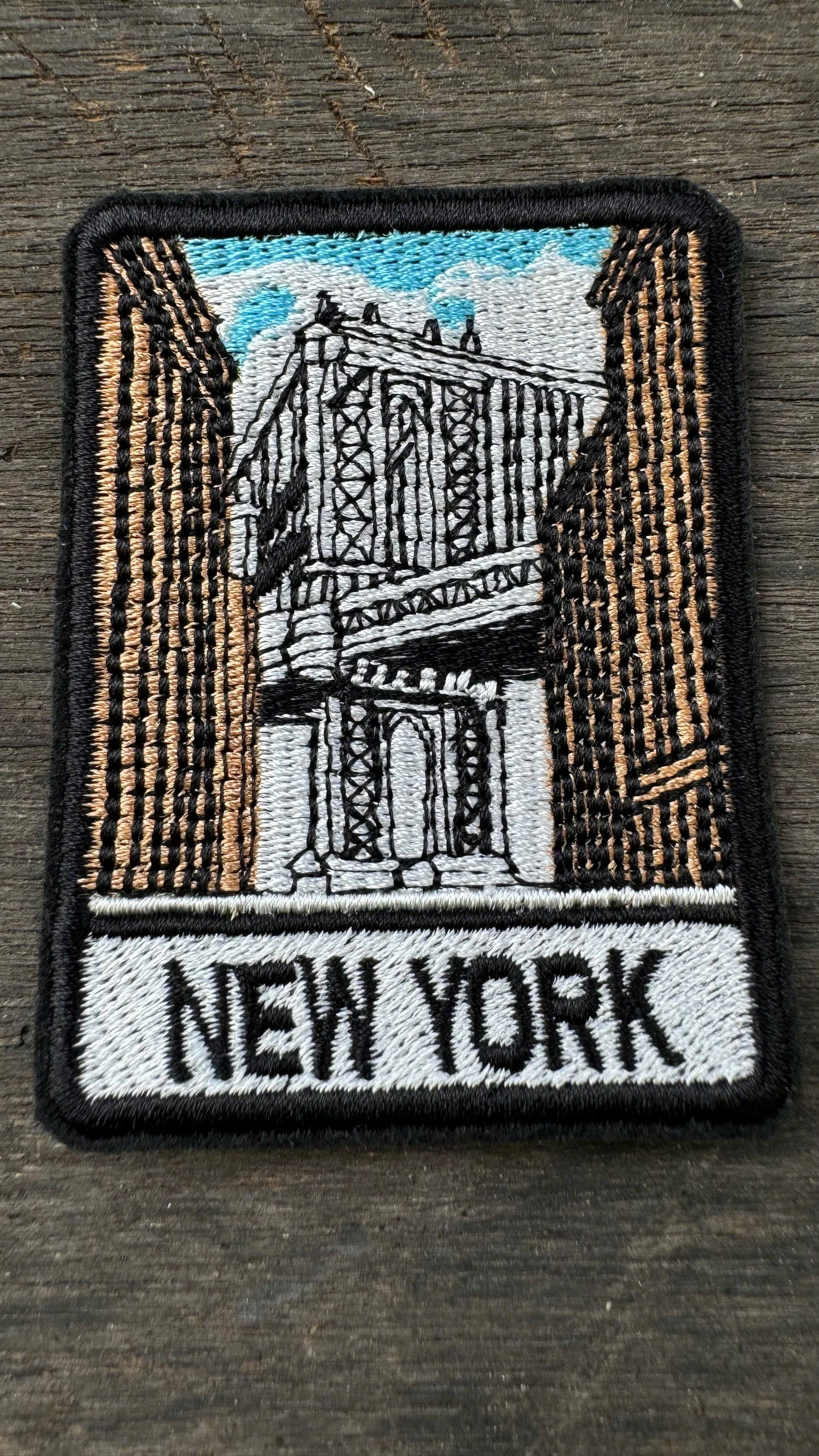 Embroidered patch with a New York Cityscape design on a wooden surface