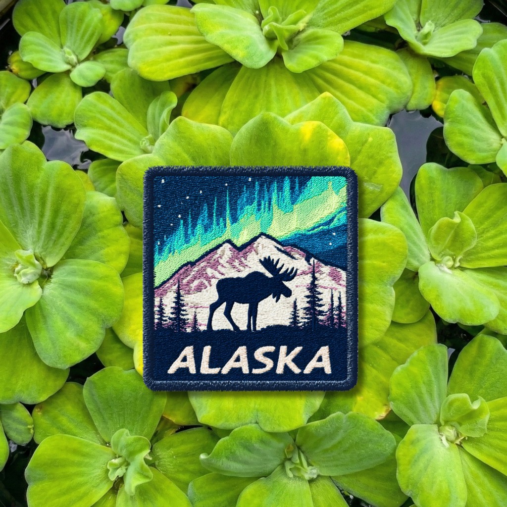 Alaska travel embroidery patch with northern lights, moose silhouette, and snowy mountains
