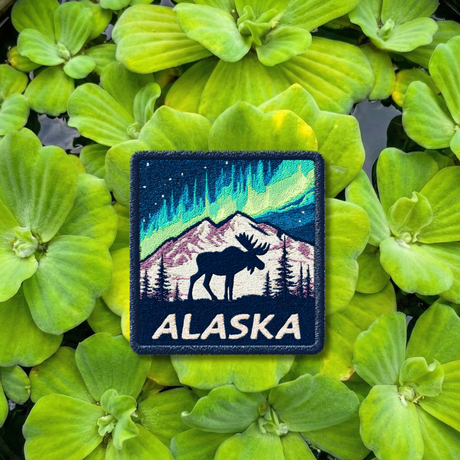 Alaska travel embroidery patch with northern lights, moose silhouette, and snowy mountains

