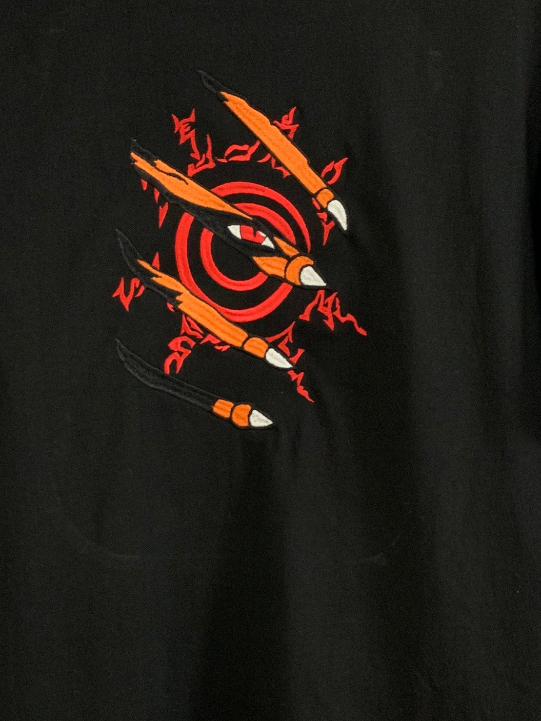 Close-up of embroidered red seal and claw design