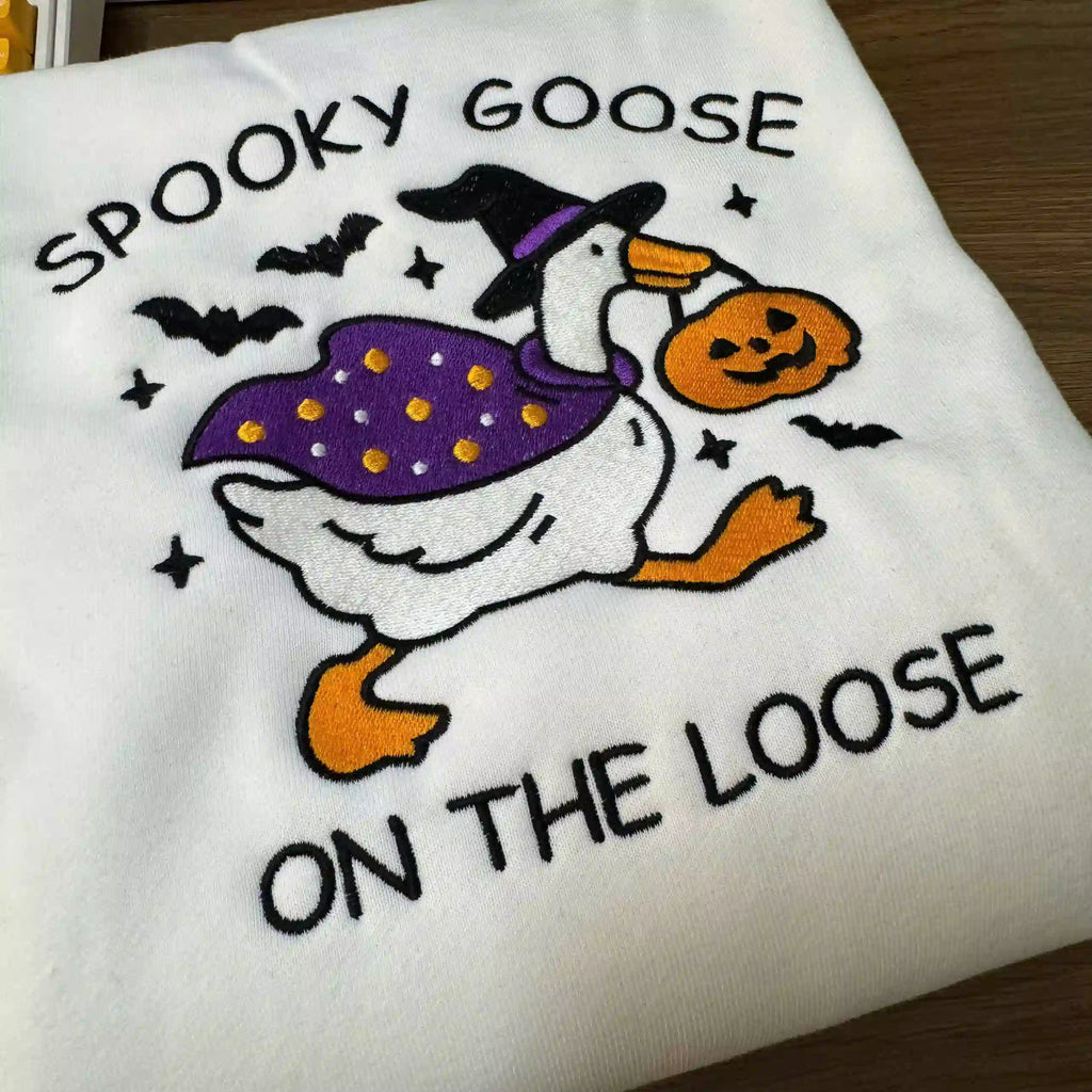 Halloween-themed towel with a goose design and text on a wooden surface