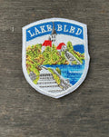 Embroidered patch of Lake Bled on a wooden surface