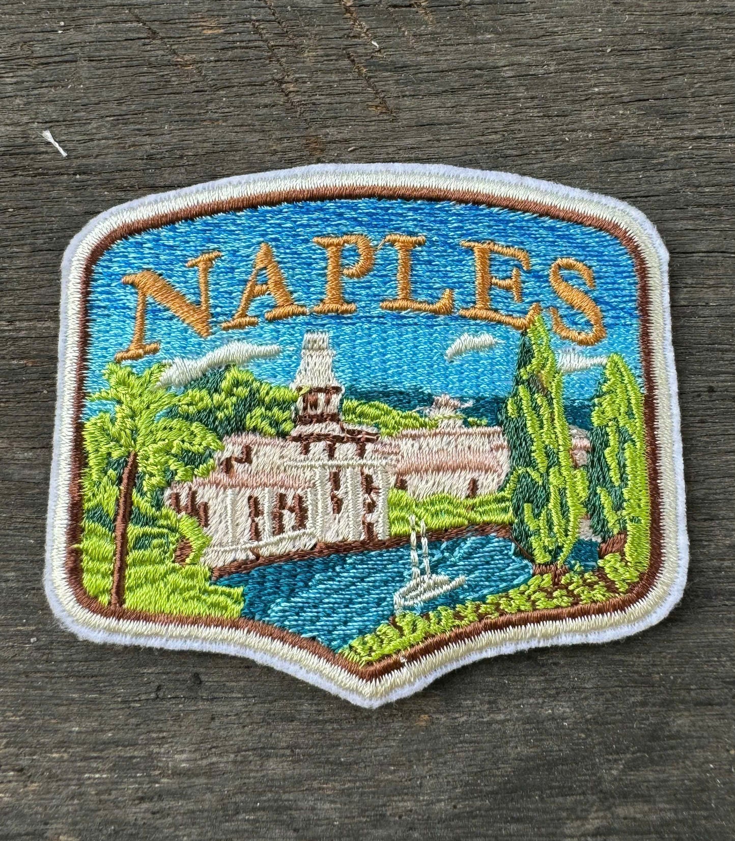 Embroidered patch of Naples on a wooden surface