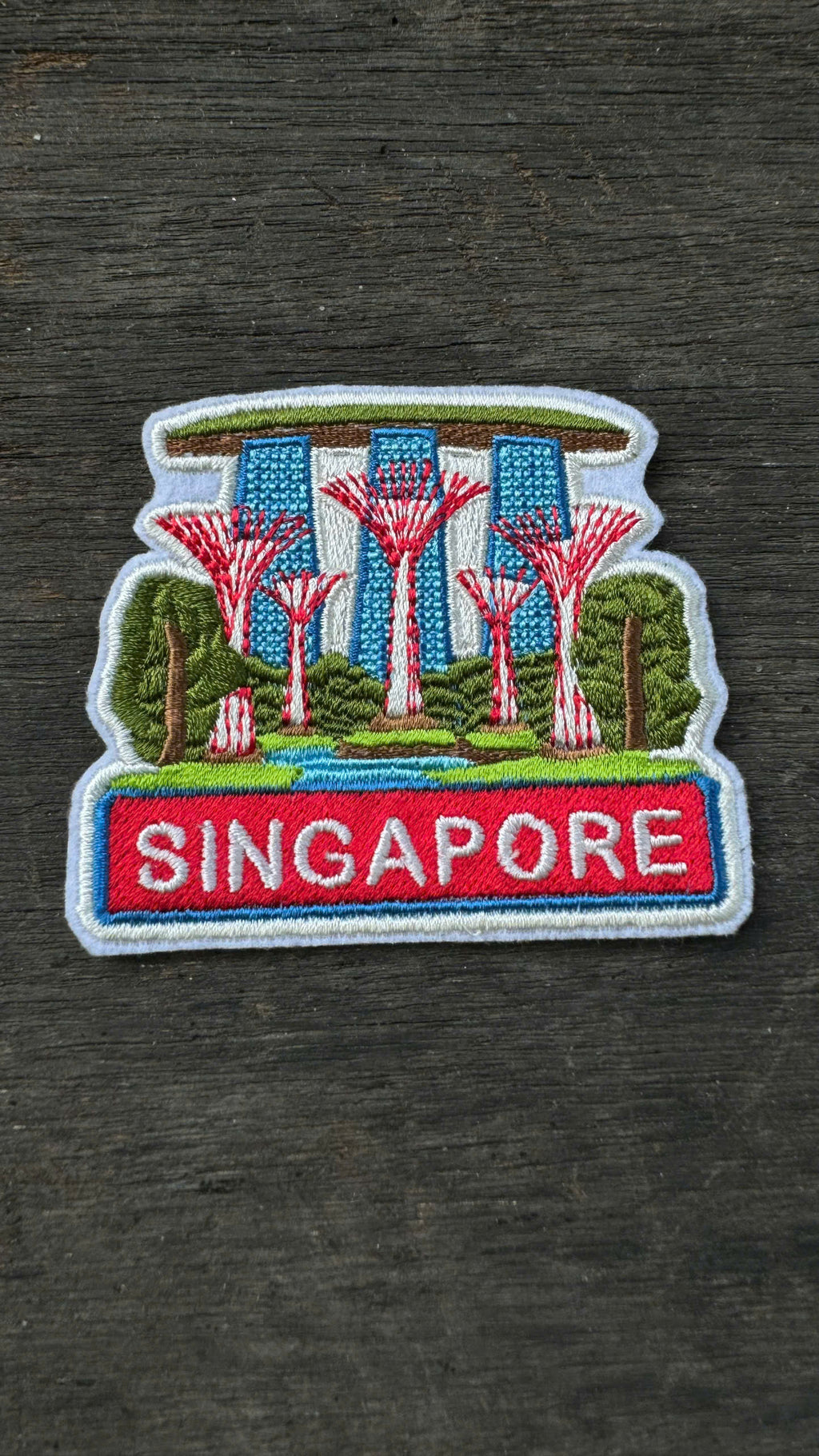 Embroidered patch of Singapore with Supertrees and Gardens by the Bay on a dark fabric background
