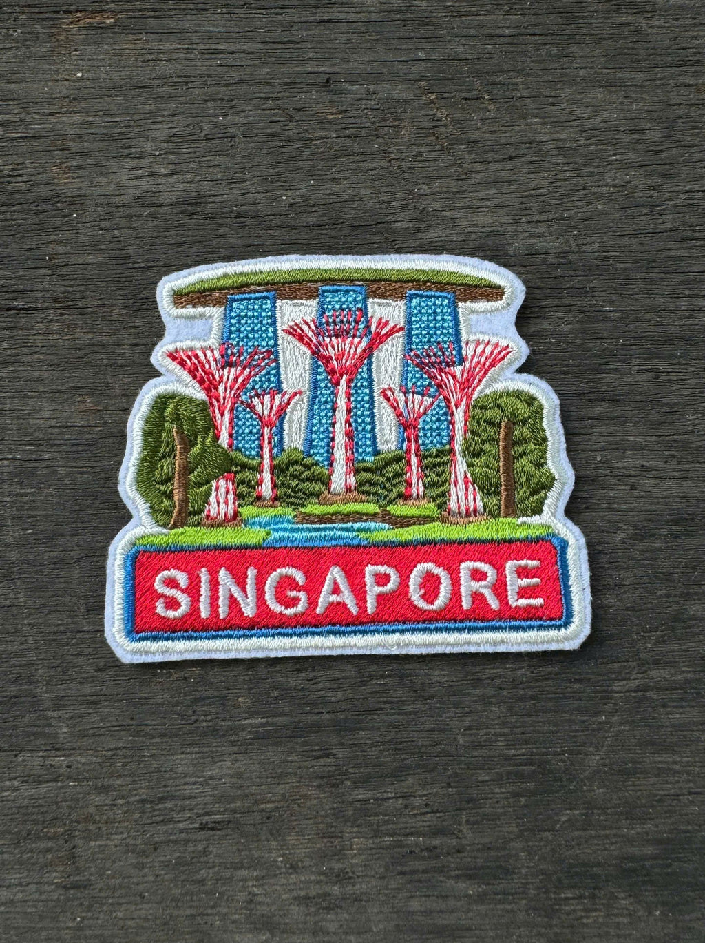 Embroidered patch of Singapore with Supertrees on a wooden surface