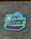 Embroidered patch of Singapore with a building design on a wooden surface