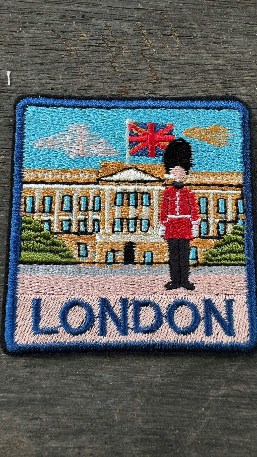 Embroidered patch with a guard and Buckingham Palace in London on a dark background
