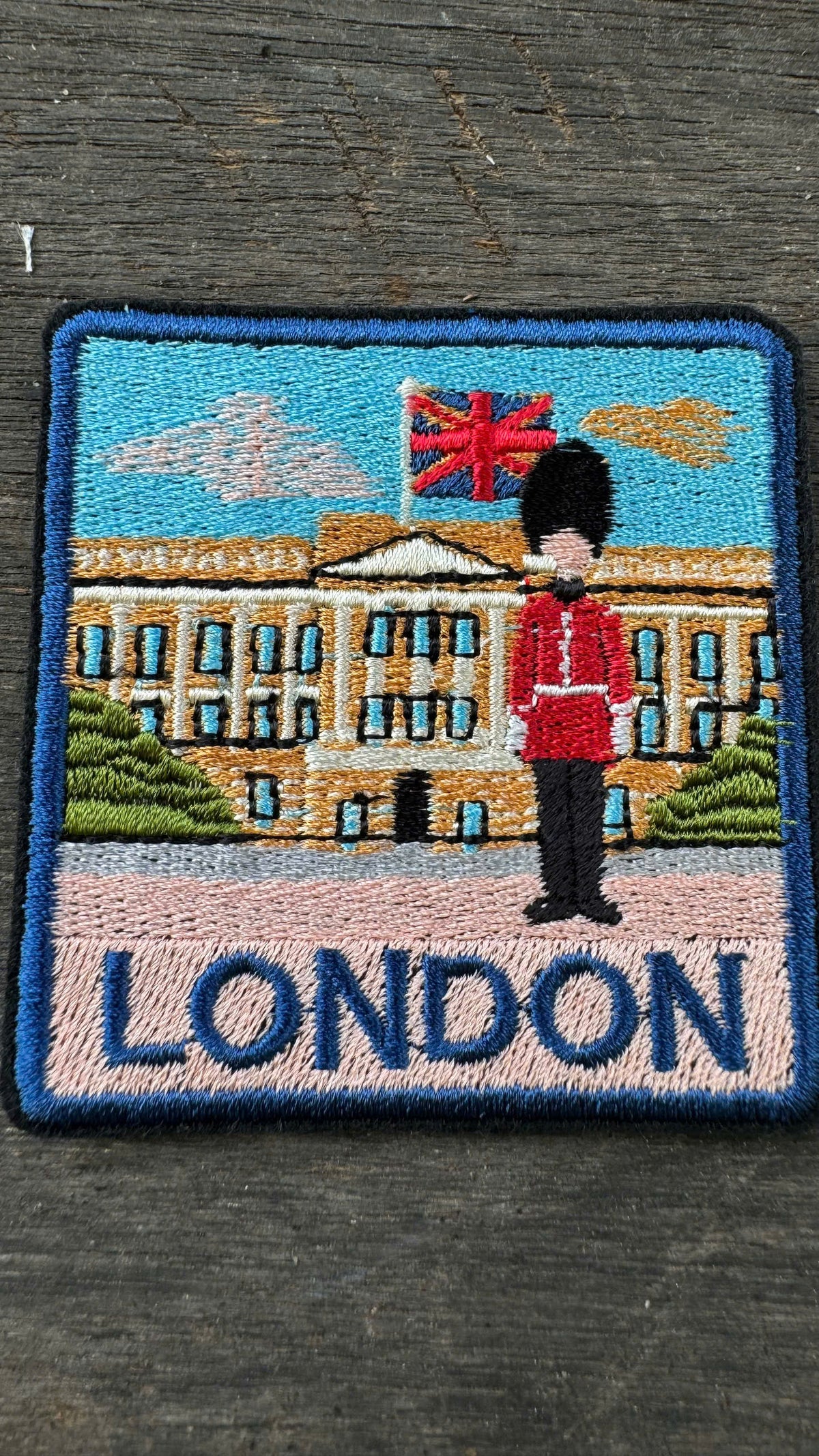 Embroidered patch with a guard and Buckingham Palace in London on a dark background