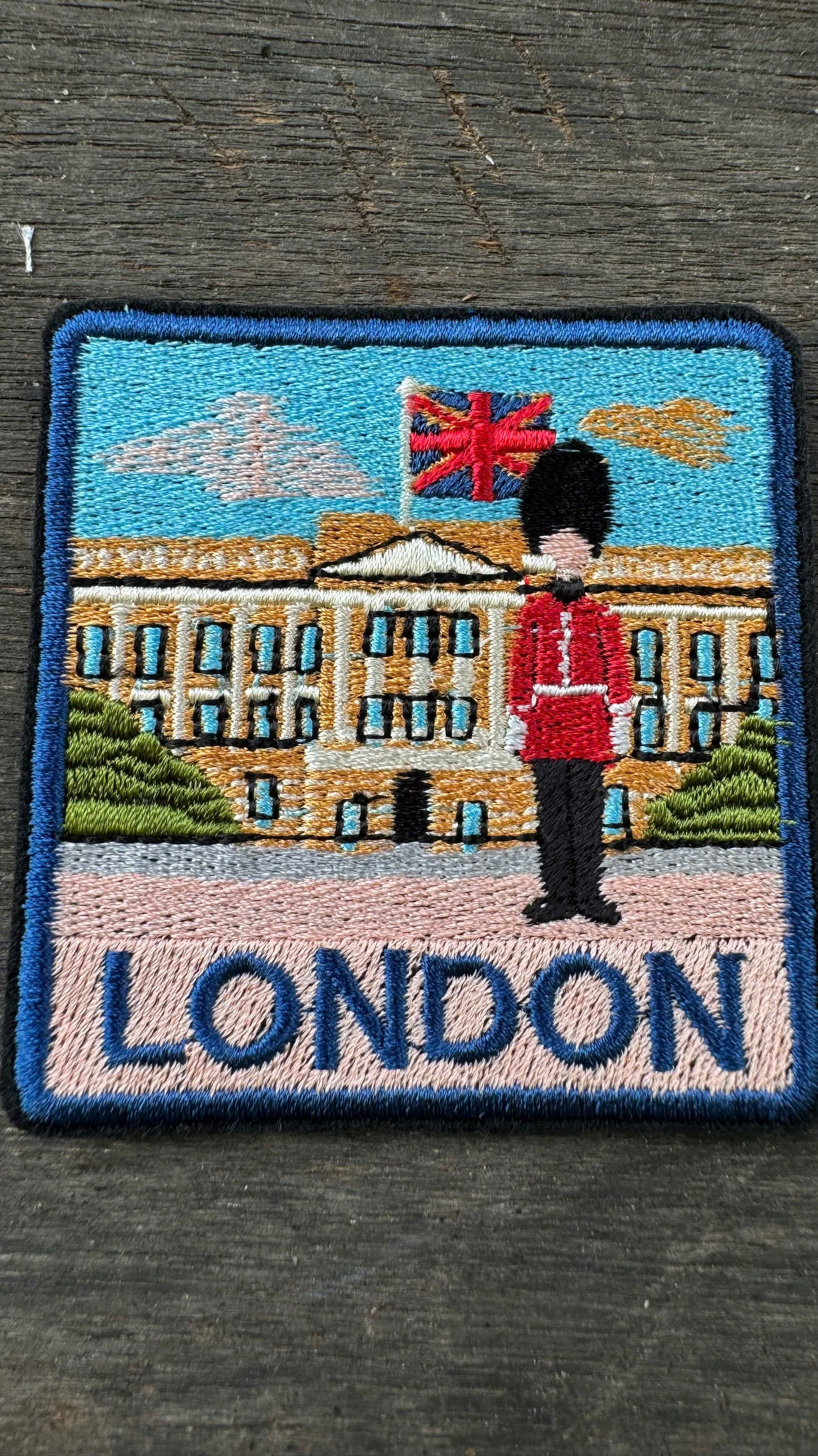 Embroidered patch with a guard and Buckingham Palace in London on a dark background