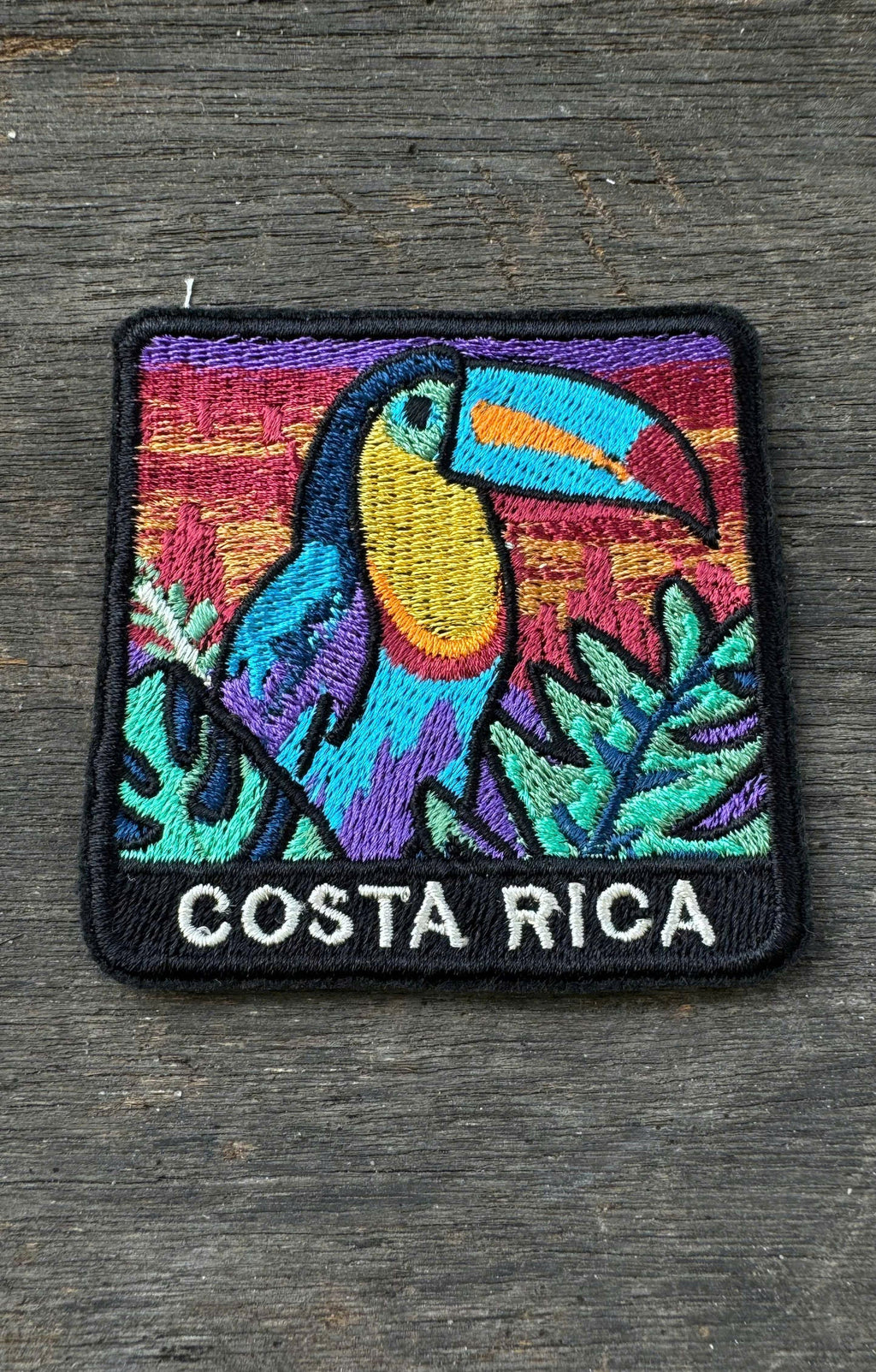 Embroidered patch with a toucan and Costa Rica text on a wooden surface