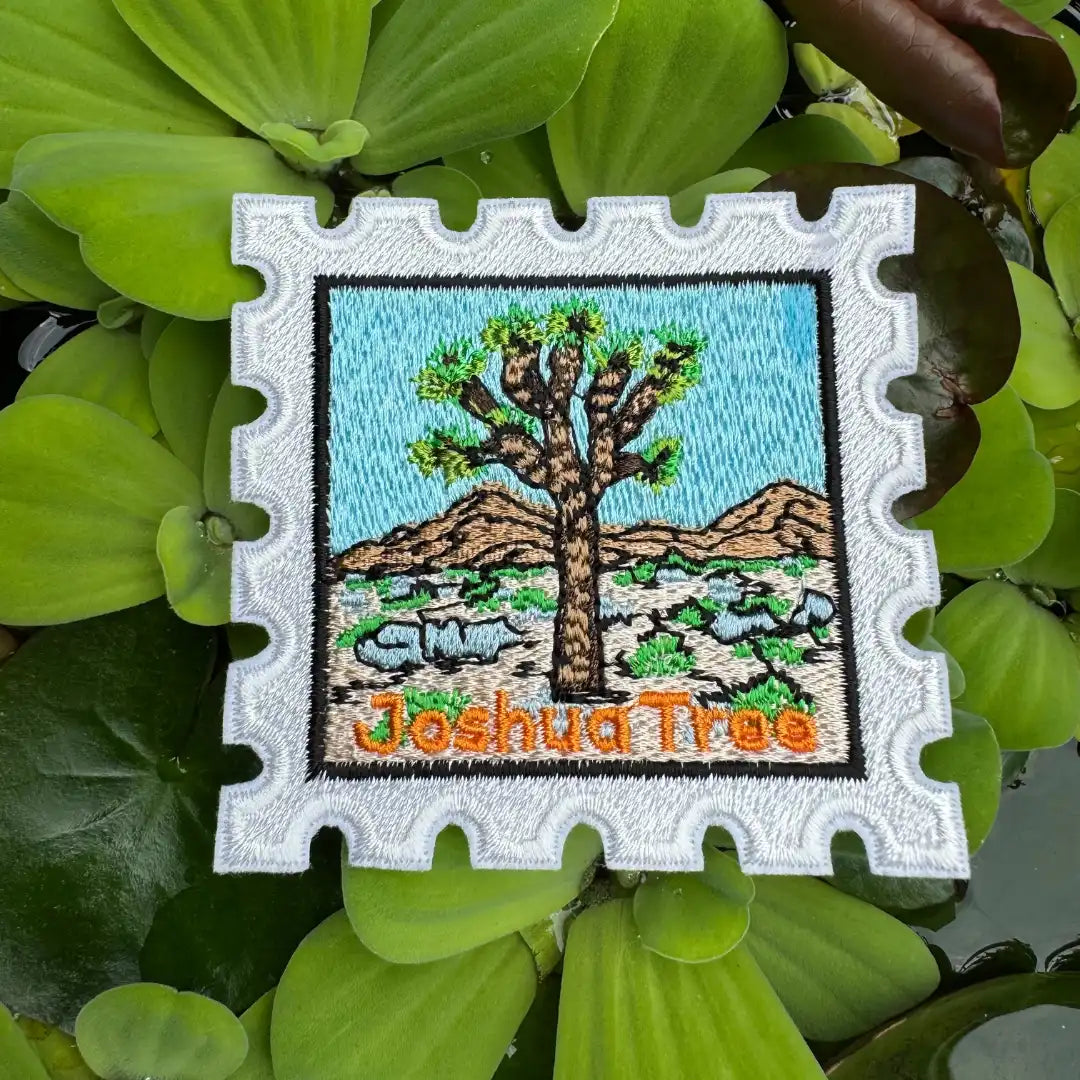 Embroidered patch of a Joshua Tree with desert landscape on green leaves