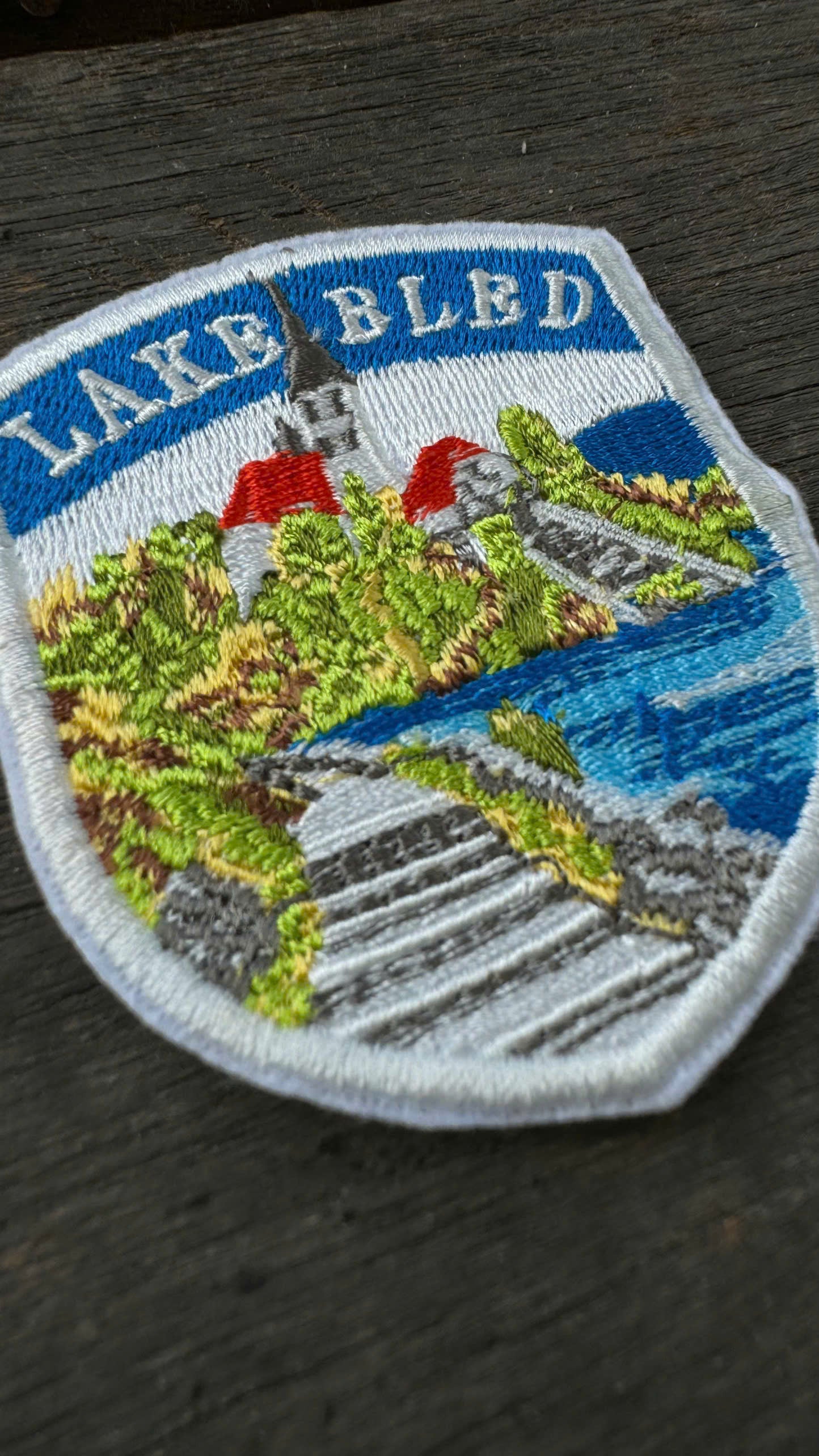 Embroidered patch of Lake Bled with scenic design on a dark surface