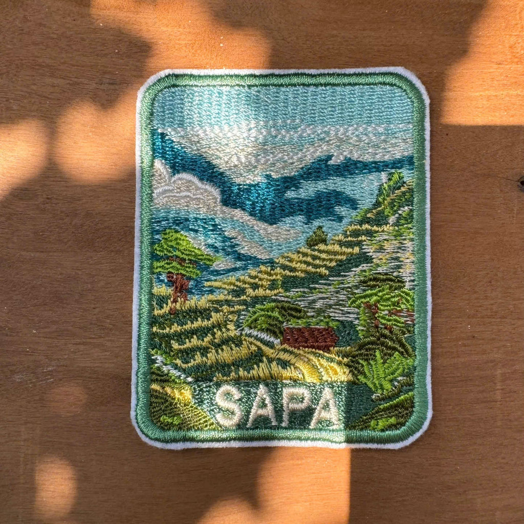 Embroidered patch with a scenic design and 'Sapa' text on a brown background